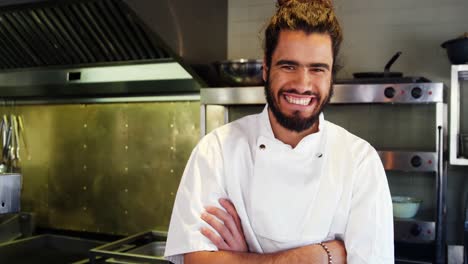 chef feliz con los brazos cruzados de pie en la cocina