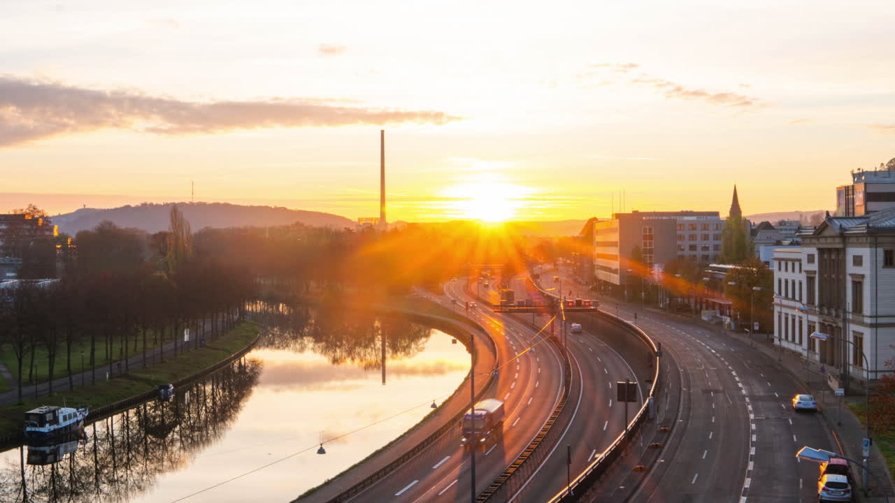 Time lapse of sunrise in Saarbrucken while many vehicles are crossing the road. Germany transportation