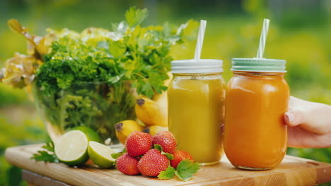 a woman's hand puts on the table three smoothies of fruit and green salad