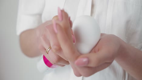 Mano-Femenina-Apretando-El-Paquete-De-Mousse-De-Huevo-Mascarilla-Facial-En-La-Palma