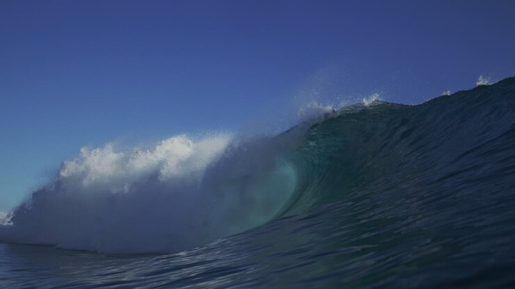 Strong ocean wave crashes white wash foam in closeout to view of backside vortex barrel