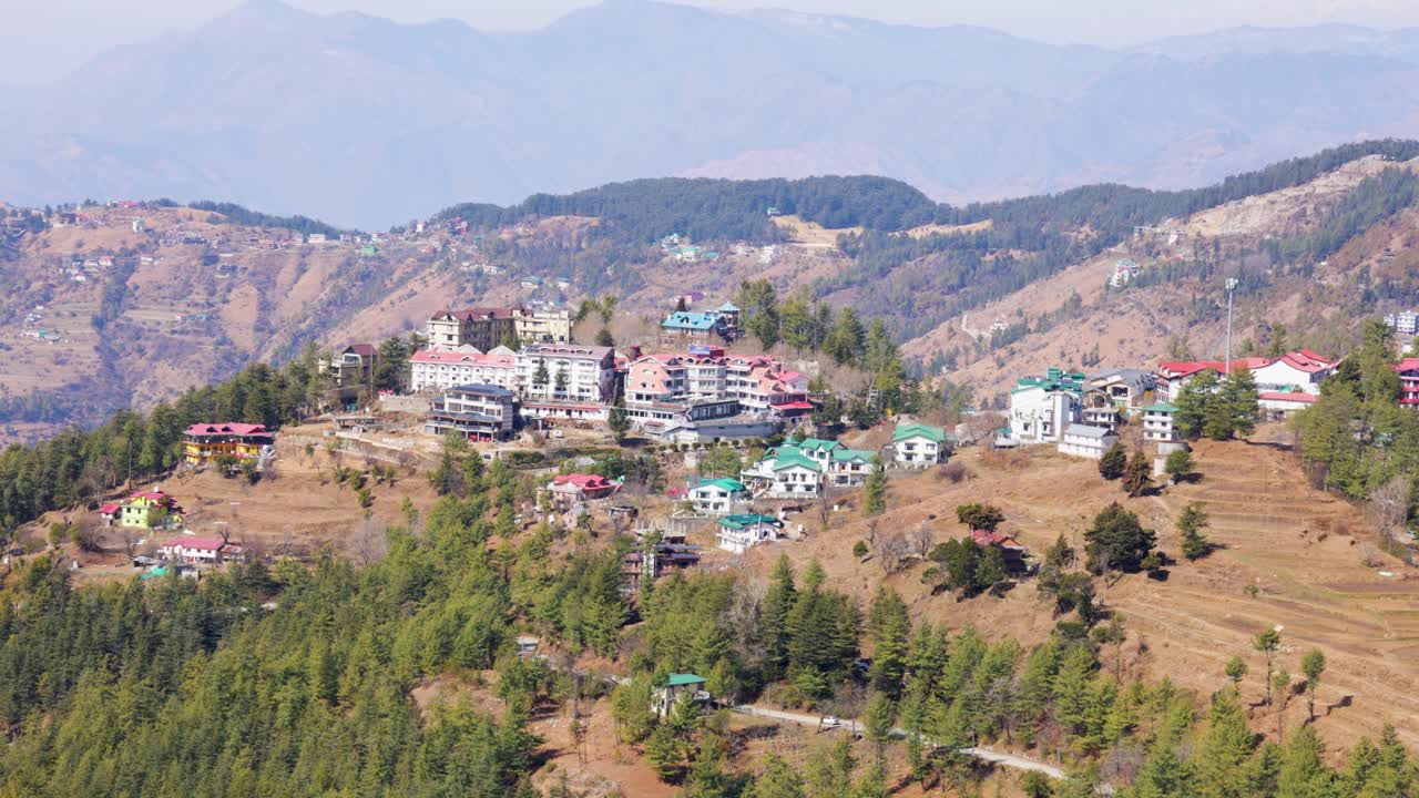 Paisaje pintoresco de estación de montaña visto desde una terraza con laderas boscosas y casas