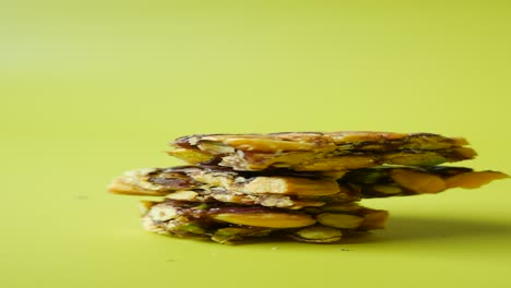 closeup of a stack of pistachio brittle on a green background