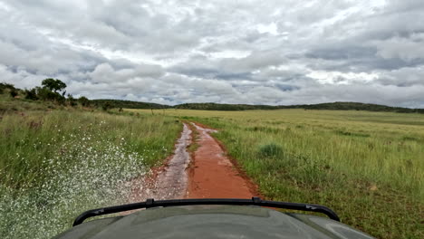 off-road 4x4 driving on a muddy trail, splashing water under dramatic rain clouds