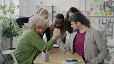 office colleagues arm wrestling
