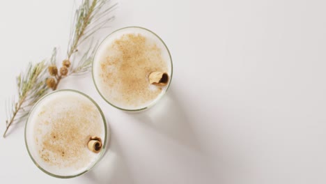 video of cups of hot chocolate with cinnamon over white background