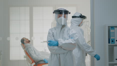 Portrait-of-dentist-standing-in-hazmat-suit-for-virus-protection