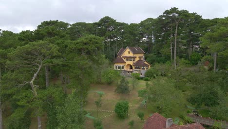 Aerial-drone-flying-around-a-villa-with-French-colonial-style-between-pine-trees-forest_Dalat-Vietnam-Aug2020_4K-60fps