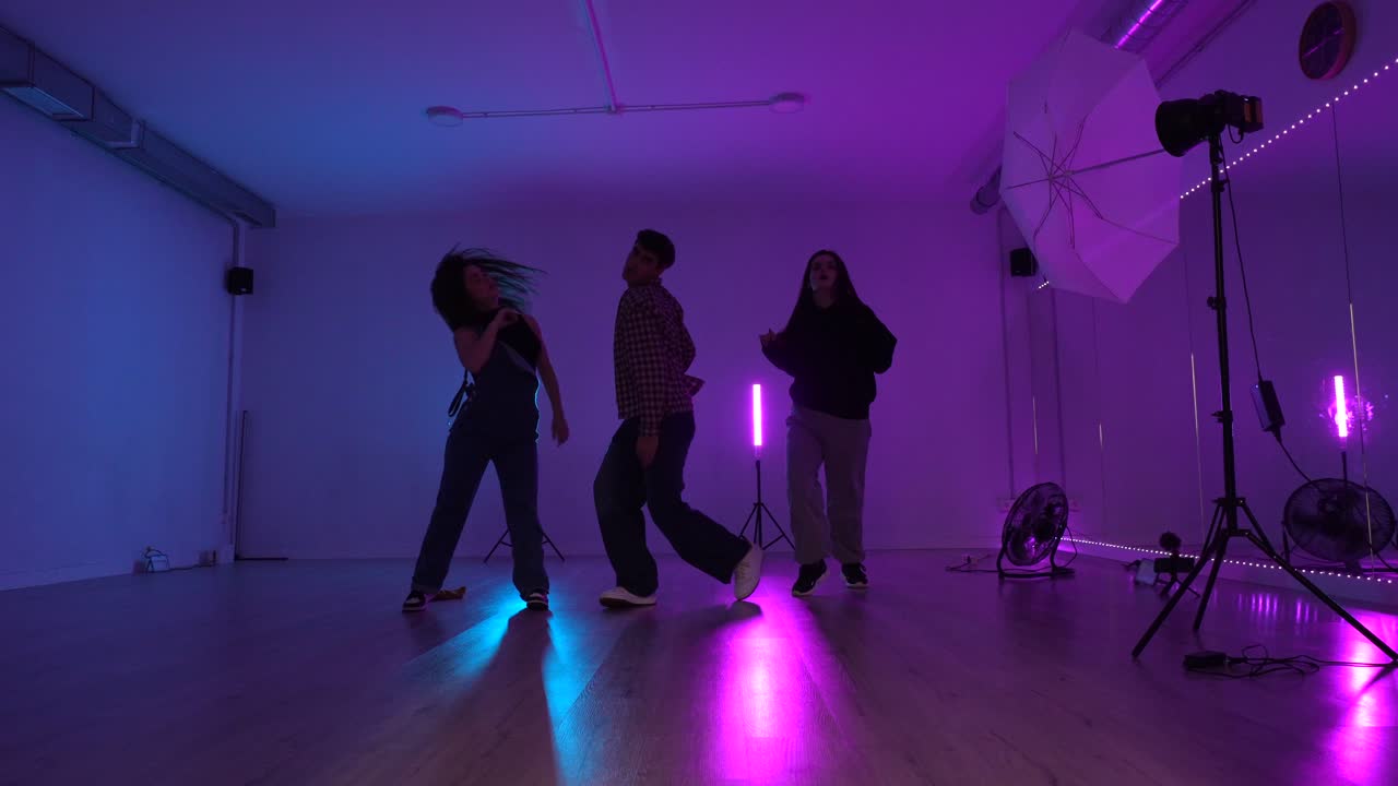 Dance performance in a studio with neon lighting