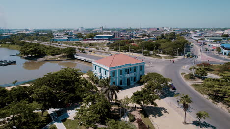 aerial-view-of-the-charming-small-Blue-House,-affectionately-known-as-Ministerio-de-Cultura,-stands-as-a-cultural-gem,-a-testament-to-heritage-and-creativity-with-city-behind