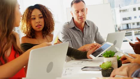 Equipo-De-Ejecutivos-Interactuando-Entre-Sí-Mientras-Trabajan-En-La-Oficina