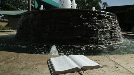 Holy-Book-by-a-Peaceful-Water-Fountain-Background-in-Slow-Motion