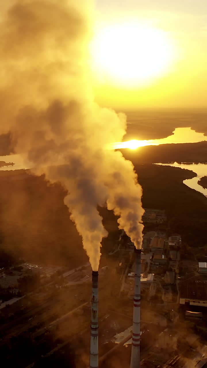 Factory chimney smoking. Gas emissions coming from the smoking chimney pipes of the power plant. Vertical video