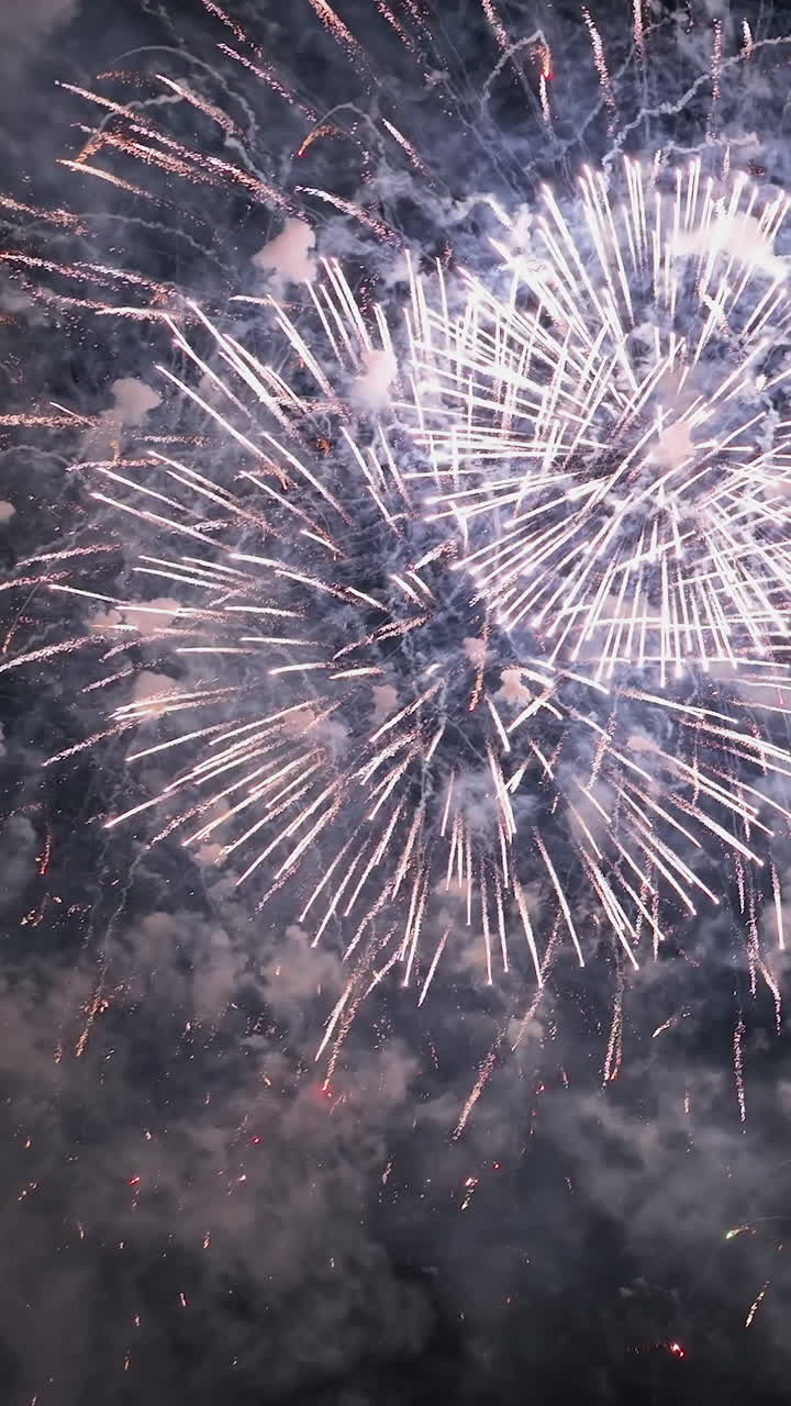 Vertical drone shot of a night sky full of colorful New year fireworks
