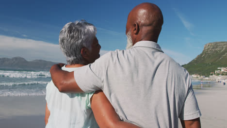 Pareja-Afroamericana-Mayor-Abrazándose-En-La-Playa