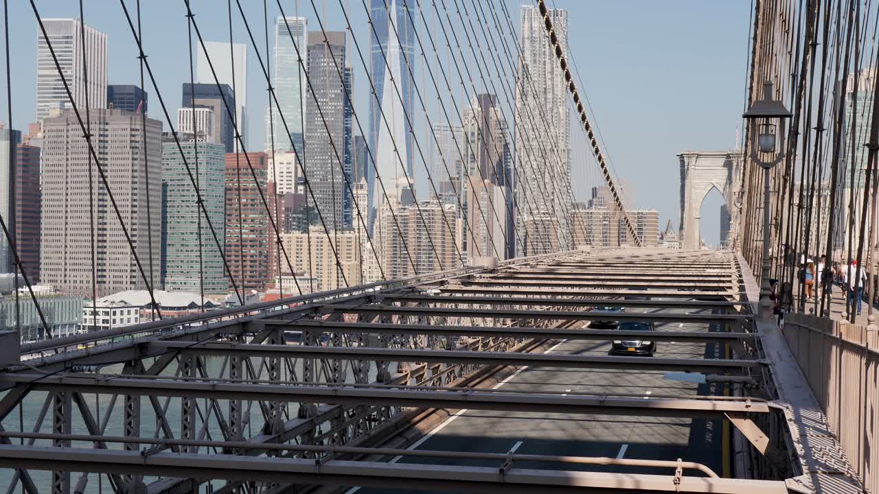 Slow motion landscape of cars transport driving on road street over Brooklyn Bridge Boulevard New York City USA arches travel tourism infrastructure Manhattan buildings towers