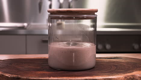 sourdough starter with bubbles rising in a glass jar for baking during fermentation