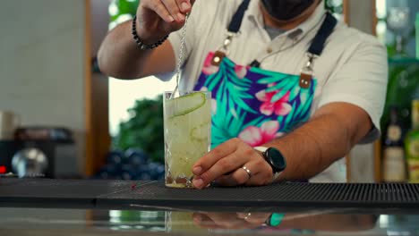 latin mexican bartender show flair routine at preparing fresh drink at beach restaurant with cucumber and citric garnish red side shot tequila sunrise mojito gin mezcal