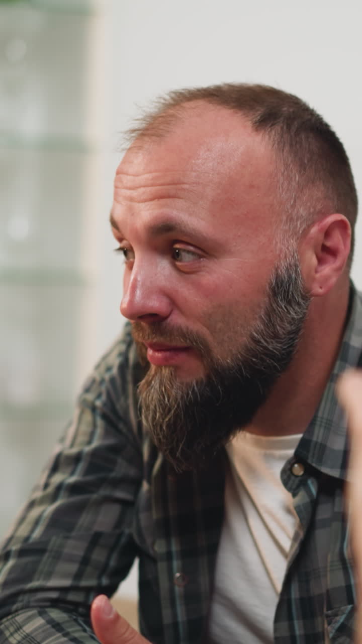 Husband and wife talk sitting at table. Bearded man tells story and woman listens attentively. Family leisure on weekday evening on blurred background closeup