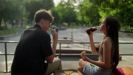 teenagers enjoying pizza and soda at a skate park