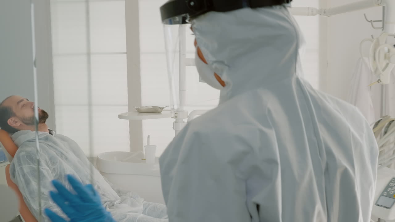 ortodontista con traje de ppe preparándose para la consulta del paciente