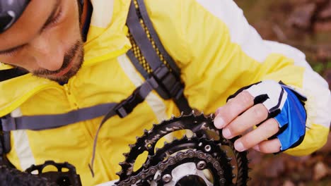 male mountain biker fixing his bike chain