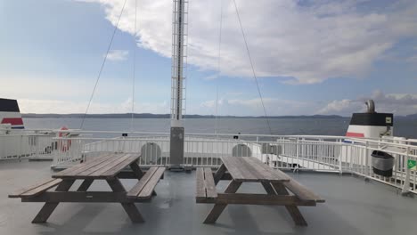 ferry boat ship bench on the open deck in bomlafjord, norway. pov shot