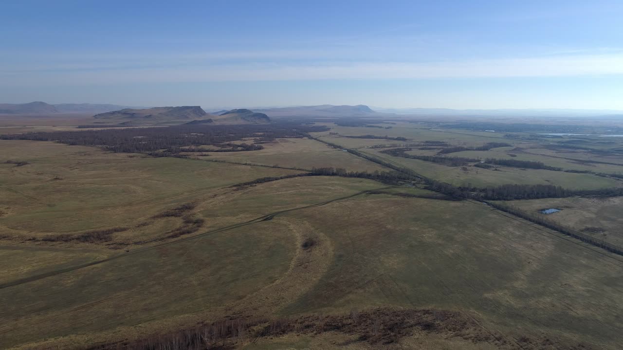 vista aérea de un campo verde con montañas en el fondo