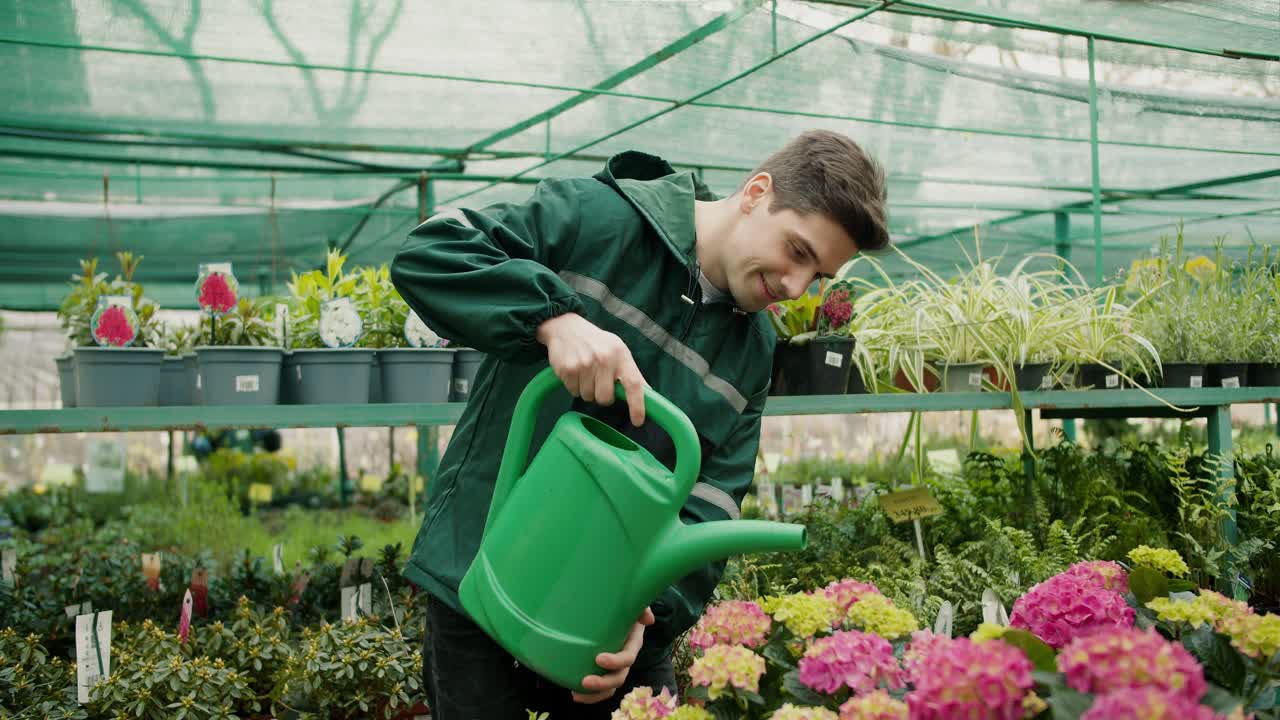 hombre uniformado verde cuidando flores en una tienda de flores especializada
