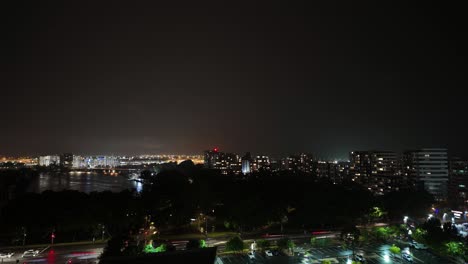 striking timelapse of princess highway’s night traffic with sydney airport in the background as lightning illuminates the stormy sky, creating a dramatic urban scene.