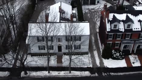 historic downtown homes in woodstock, vermont in winter in snow - aerial flyover