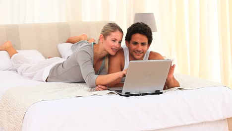 una pareja encantadora usando una computadora portátil