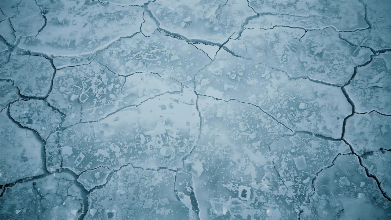 Die Kamera beginnt, rissige Eisplatten und dunkle Spalten an einem gefrorenen Teich mit treibenden Eispartikeln zu enthüllen
