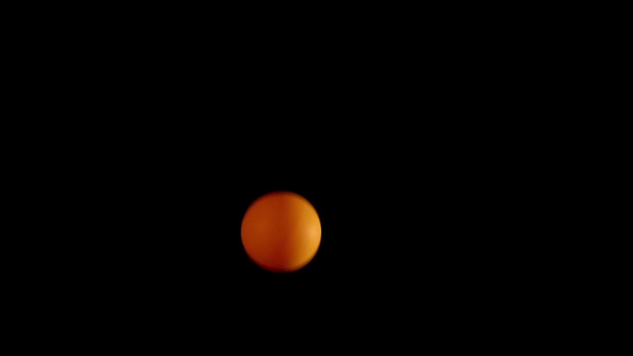 Orange spheres captured in a vertical motion sequence against a dark background.