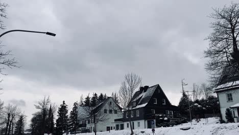 Häuser-Auf-Einer-Straße-Mit-Schnee-Im-Winter-In-Einer-Laterne-Im-Vordergrund-Und-Einem-Bewölkten-Himmel
