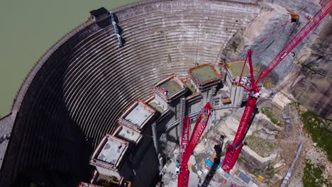 Aerial-drone-shot-over-a-under-construction-dam-beside-Hotel-Grimsel-Hospiz-along-Grimsel-Pass,-Swiss-Mountain-in-Switzerland-at-daytime