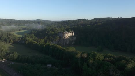 flying towards famous walzin castle belgium during sunrise, aerial