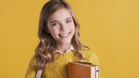 happy teenage caucasian girl student holding notebooks.