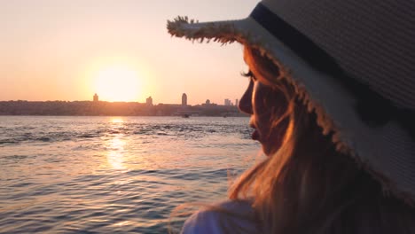 cámara lenta: hermosa chica disfruta de la vista del atardecer del bósforo y estambul, un destino popular en estambul, turquía