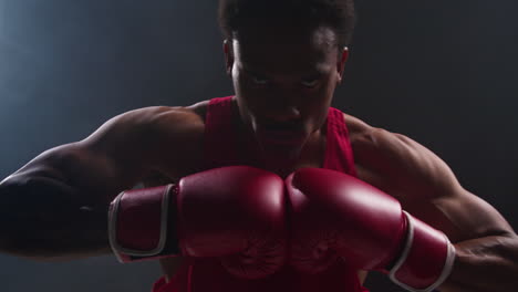 retrato cercano de un boxeador golpeando guantes juntos en el ring antes del comienzo de un partido de boxeo