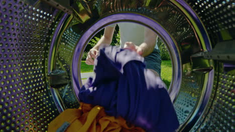 man loading clothes into washing machine in garden