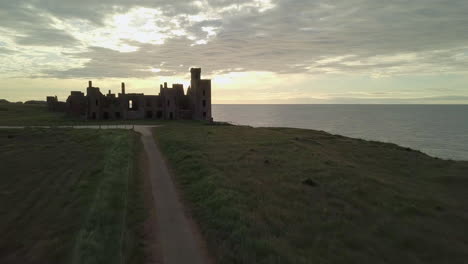 Aerial-view-of-a-Slains-Castle-ruin-at-sunrise,-Aberdeenshire,-Scotland