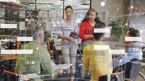two women leading business meeting while three men sitting showing tablet graphs and data overlay