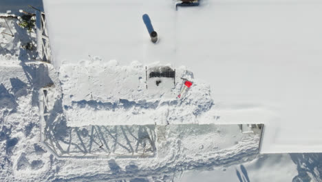 Disparo-De-Dron-Sobre-Un-Showel-Y-Un-Raspador-Encima-De-Un-Sistema-Fotovoltaico-En-Una-Casa-Nevada