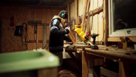 A-Man-is-Using-a-Circular-Saw-to-Cut-a-Wooden-Plank---Static-Shot