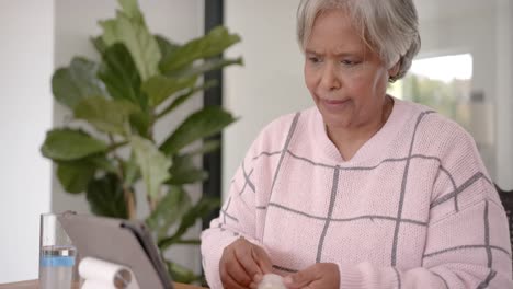 mujer de dos razas usando una tableta para una consulta médica, cámara lenta