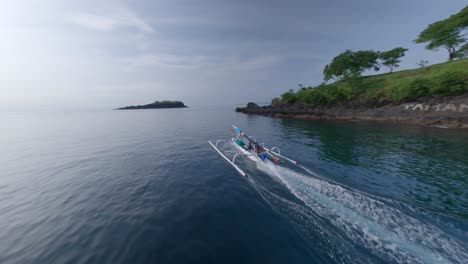 traditional indonesian boat sailing over a calm sea on a sunny day