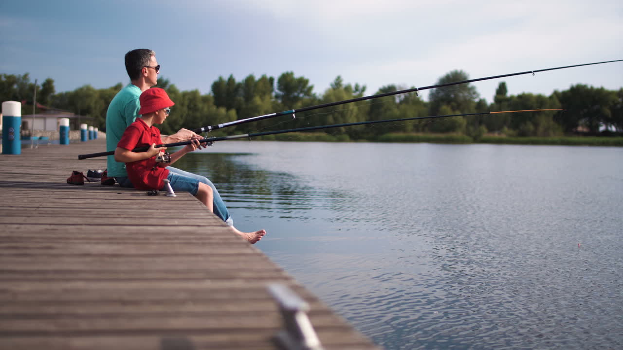 Father and son fishing on a lake pier