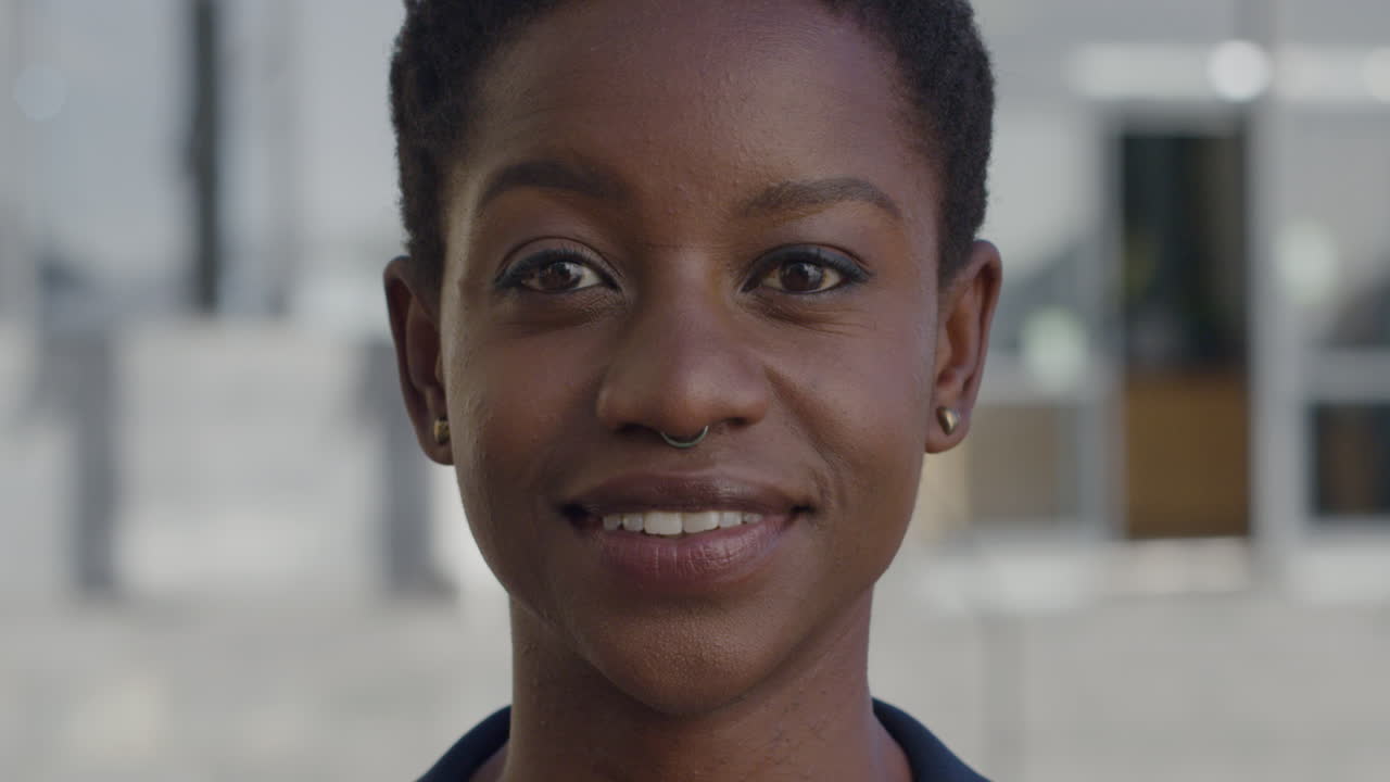 retrato de una feliz mujer afroamericana sonriendo en una escena urbana