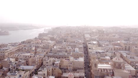 Drone-rising-high-above-the-old-town-of-Valletta-Malta-on-a-hazy-day